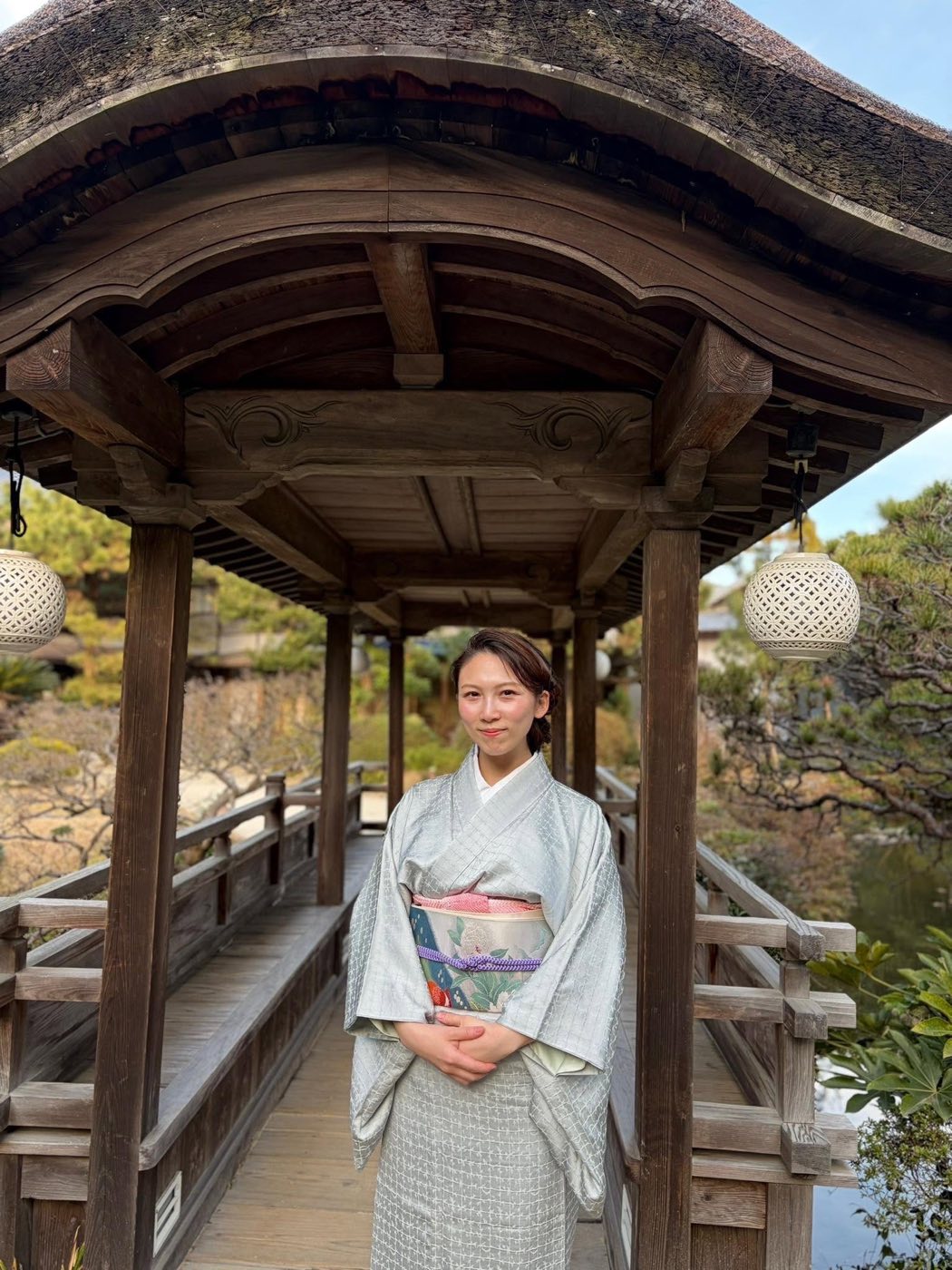 日本庭園の橋の上に立つ茶道家・笹木椿